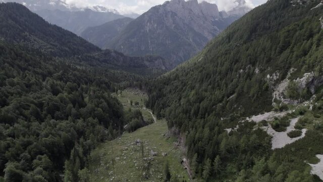 Drone video with descriptive frontal shot over the Vrsc pass in Slovenia with mountains on the horizon.
