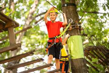 Boy climber walks on the rope bridge,