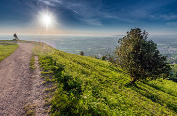 A man watches the sun rise from the Malvern Hills,Worcestershire,England.
