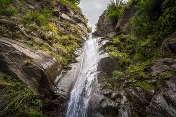 Naklejka na ściany i meble Selective blur on water falling from the Finsterbach wasserfalle waterfalls, in Sattendorf. These are typical mountain alpine waterfalls in the middle of the alps in Carinthia. ....