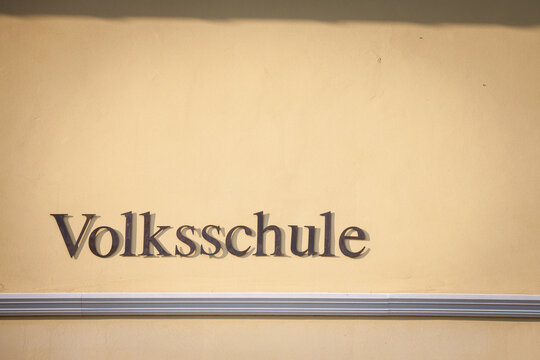 Sign indicating Volksschule, meaning in german People's school, on a building in Austria. Volksschule in Germany, Austria and Switzerland englobes primary and secondary school levels for students