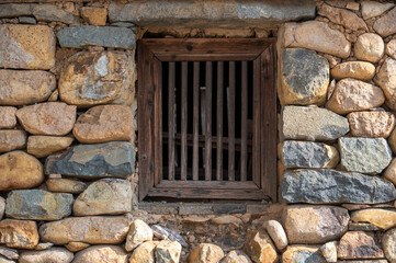 Fototapeta na wymiar There is a window on the stone wall