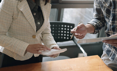 Businessman holding pens and holding graph paper are meeting to plan sales to meet targets set in next year...