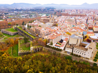 Aerial panorama of historic centre of medieval fortified city of Pamplona in background with silhouette of mountains in autumn day, Navarre, Spain..