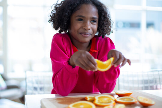 Young girl at counter with orange slices