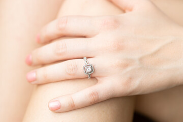 Manicured hand of newly engaged bride. Elegant silver diamond ring. Engagement photo shoot.  romantic thoughts about the future.