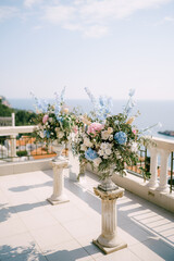 Fototapeta na wymiar Bouquets of flowers stand on a terrace overlooking the sea