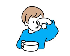 ご飯をスプーンで食べる幼児