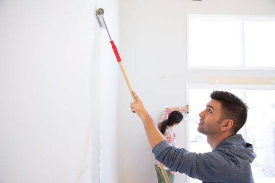 Young Couple Painting Walls At Home