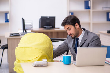 Young male employee looking after new born at workplace