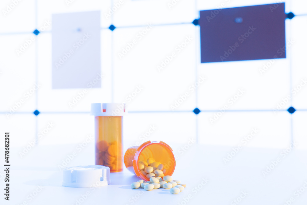 Sticker Medical pills and tablets spilling out  drug bottle. View with copy space.