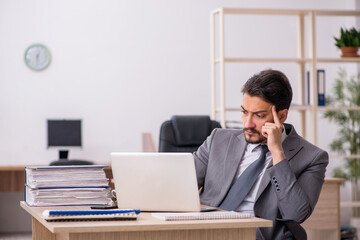 Naklejka premium Young male employee working in the office