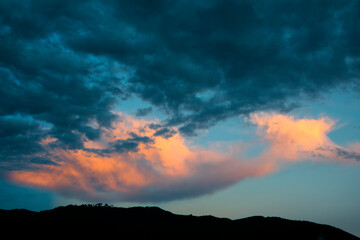 Dramatic sunset in rural Guatemala, silhouettes of mountains and colorful sky in clouds of January 2022.