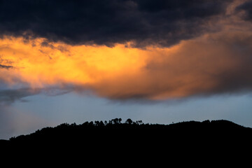 Dramatic sunset in rural Guatemala, silhouettes of mountains and colorful sky in clouds of January 2022.