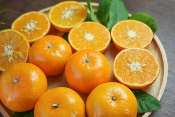 Tangerine Taiwan Orange with slices on wooden, Mandarin Orange fruit in wooden basket on wooden table in garden.