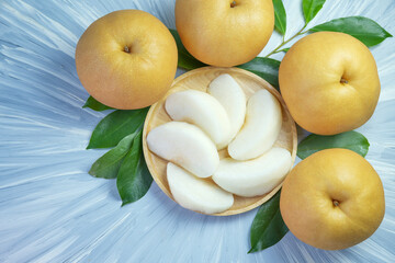 Peeled Snow pear fruit in wooden basket, Fresh Nashi pear or Korean pear fruit in the basket over green natural Blur background.