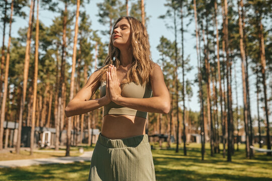 Cute blonde woman practising yoga outside and looking relaxed