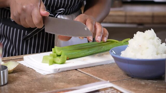 Chopping organic celery to add to a homemade recipe - side view slow motion GUMBO SERIES