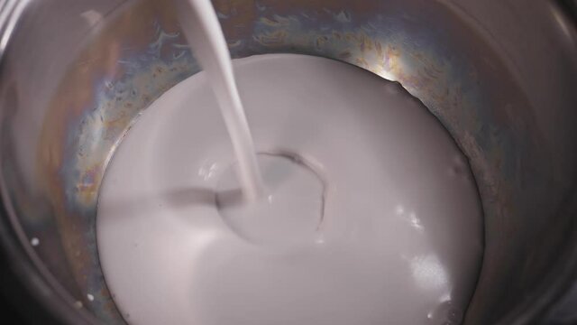 Choco Oat Cake Recipe. Pouring Coconut Milk Into Stainless Pot. close up