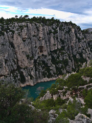 View of the rugged cliffs of mountain range Massif des Calanques near Cassis, French Riviera at the mediterranean sea with pine trees and narrow bay.