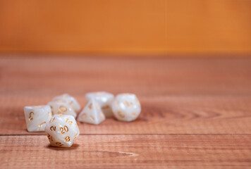 Set of role playing white dices on a gaming table made of wood: table for role-playing games with place for text, side view