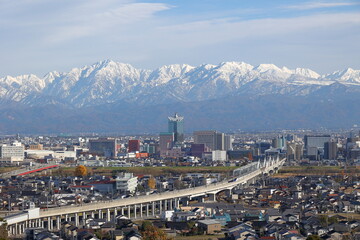 雪化粧した山と市街地の風景