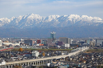 雪化粧した山と市街地の風景