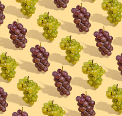 Pattern made with green and purple grapes on pastel background. Sunny idea nature aesthetics.