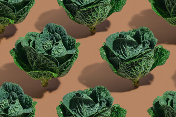 Pattern made of fresh green cabbage on a pastel brown background. Organic food concept.