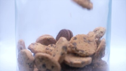 Slow Motion shot of cookies falling into a cookie jar until it's full