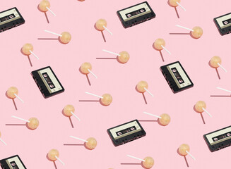 Audio cassettes and lollipops on stick on pink background. Retro pattern. Discos, friends, great...