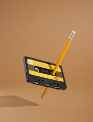 Audio cassette and pencil to rewind the magnetic tape float in the air. Minimalistic retro...
