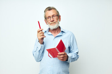 Photo of retired old man red notepad writing light background