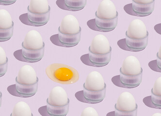 Pattern of white chicken eggs in special stands and broken raw egg. Use of eggs in cooking, full healthy breakfast and rich vitamins product.