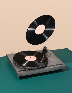 Retro composition of vinyl record player and floating record. Atmosphere of discos, good creative mood and aesthetics of luxurious rest.