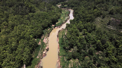 Fototapeta na wymiar Aerial view of a river in the middle of a forest in a mountainous area in Yogyakarta