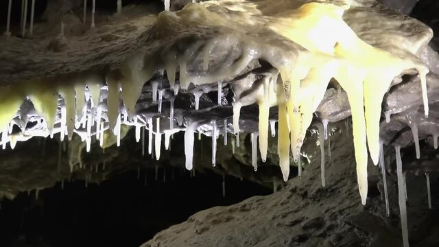 Pale yellow calcite stalactites on cave roof look like melted cheese