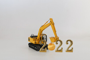 Concept Happy new year 2022,excavator of lift up bucket that is installing the ball .