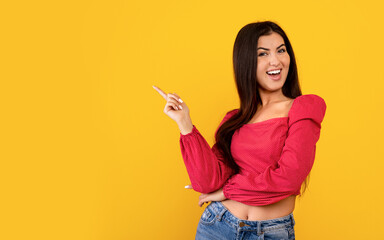 Special offer concept. Excited armenian lady pointing finger at empty space on yellow background,...