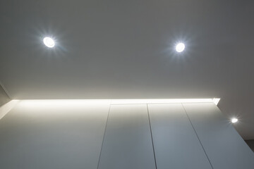 suspended or stretch ceiling with halogen spots lamps and drywall construction in empty room in...