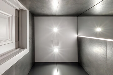 suspended or stretch ceiling with halogen spots lamps and drywall construction in empty room in apartment or house