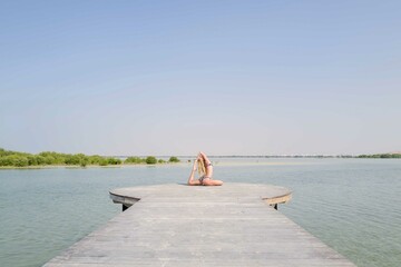 Woman doing yoga on the wooden platform