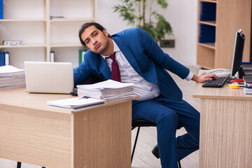 Young male employee in multitasking concept