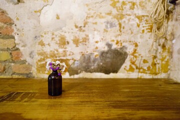 Wildflower in a small vase on the table in the rustic vintage cozy café
