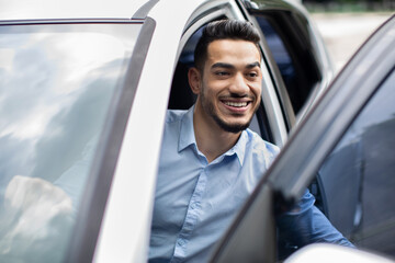 Closeup of middle-eastern businessman getting out auto