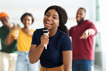 Pretty black woman with microphone singing karaoke