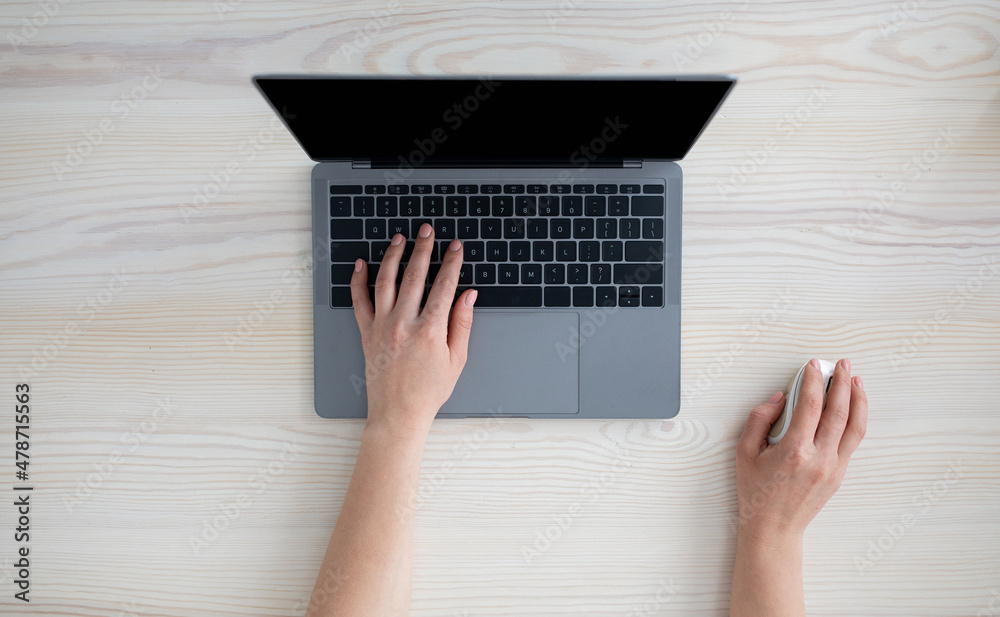 Aufkleber Technology concept. Woman using personal laptop with empty monitor, typing on keyboard and holding computer mouse