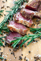 dried and spiced meat sliced on a wooden board
