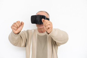 technology, augmented reality, gaming, entertainment and people concept - senior man with virtual headset or 3d glasses playing videogame at home.