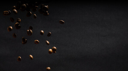 many flying coffee beans on black background